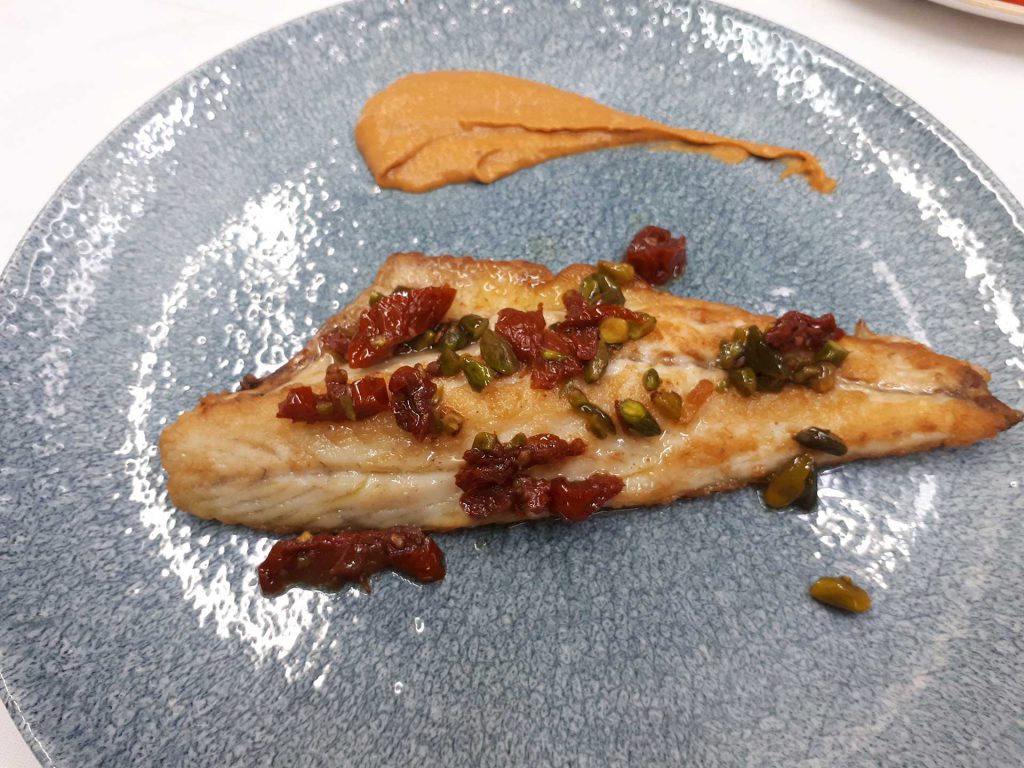 LUBINA A LA PLANCHA CON TOMATE SECO, PISTACHOS Y ROMESCU